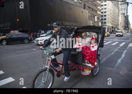 Maman de deux filles voyage dans un pedicab vers le bas 5e Avenue à Manhattan sur le Black Friday, le lendemain de Thanksgiving. Banque D'Images