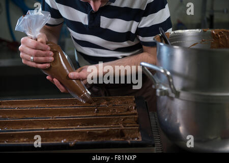 Dans son atelier de pâtisserie au chocolat préparation Yule de sciage Banque D'Images