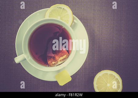 Vue aérienne de tasse de thé et tranche de citron sur fond brun Banque D'Images