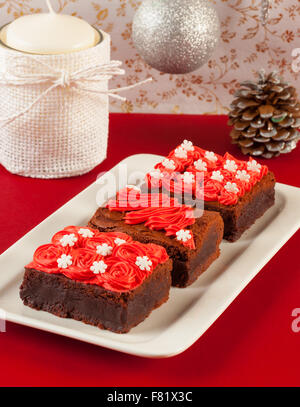 Trois brownies au chocolat de noël sur un chiffon et décorations de table rouge Banque D'Images