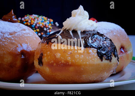 Traditionnel avec élégance Sufganiyot rond donut frites consommées pendant la fête juive de Hanoukka, la fête des lumières Banque D'Images