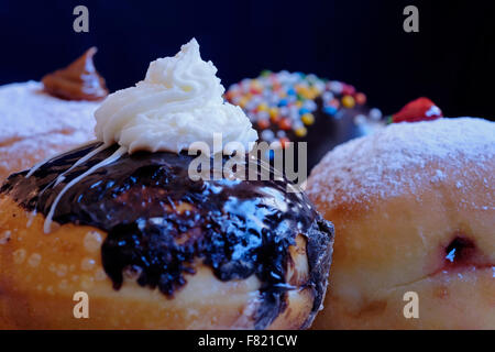 Traditionnel avec élégance Sufganiyot rond donut frites consommées pendant la fête juive de Hanoukka, la fête des lumières Banque D'Images