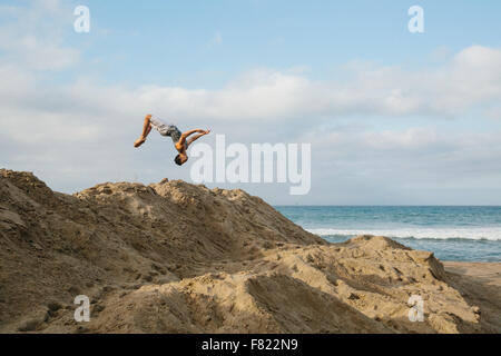 Un jeune homme se retourne plus de dunes de sable sur une plage en Californie Banque D'Images