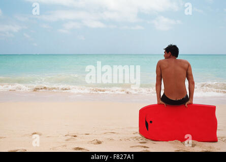 Homme avec planche de surf à la plage Banque D'Images