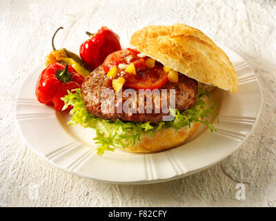 Près d'un burger de boeuf, dans un hambuger rouleau croustillant blanc avec relish tomate et laitue peppersand Banque D'Images