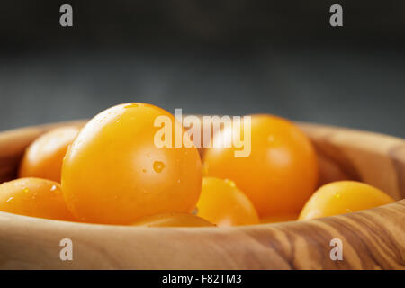 Tomates cerises jaunes dans un bol en bois Banque D'Images