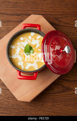 Soupe au poulet dans un bol sur la plaque en bois rouge Banque D'Images