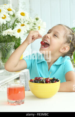 Cute Little girl eating cherries Banque D'Images