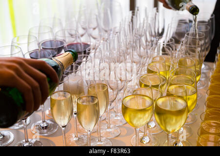 Serveurs versé dans des verres de vin et champagne Banque D'Images