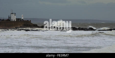 Porthcawl, Pays de Galles, Royaume-Uni, 5 décembre 2015. Un photographe se met en danger pour capturer les énormes vagues battant la côte sud du Pays de Galles. Crédit : Tom Guy/Alamy Live News Banque D'Images
