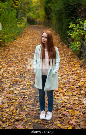 Femme rousse à l'extérieur portant un manteau 3/4. Banque D'Images