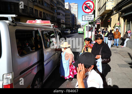 Les gens de se mettre sur un minibus à côté d'un panneau interdisant l'Il, La Paz, Bolivie Banque D'Images