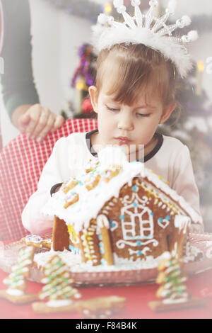 Fille orne gingerbread house Banque D'Images