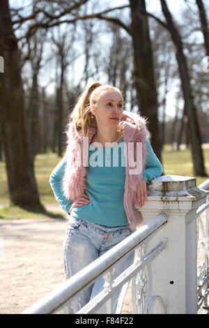 La jeune femme dans des vêtements dans spring park Banque D'Images