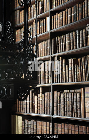 Livres anciens sont stockés sur les étagères à l'intérieur de la longue pièce de l'ancienne bibliothèque du Trinity College de Dublin, Irlande Banque D'Images
