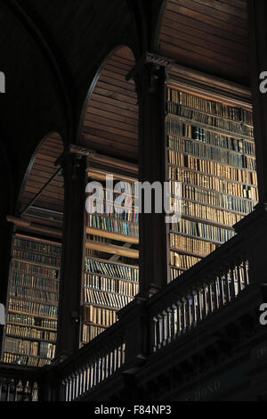 Livres anciens sont stockés sur les étagères à l'intérieur de la longue pièce de l'ancienne bibliothèque du Trinity College de Dublin, Irlande Banque D'Images