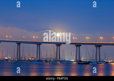 La Lune se levant sur le Coronado Bridge et la baie de San Diego. Coronado, en Californie, aux États-Unis. Banque D'Images