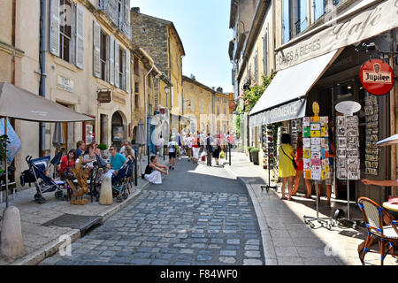 Village de Lourmarin dans le Luberon Provence de touristes se relâcher à l'ombre au café en plein air tables dans rue étroite Banque D'Images