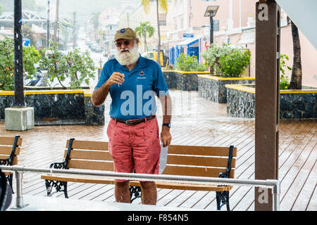 Le propriétaire de la grande barbe Charter Company de Christiansted, USVI, parle aux passagers avant le lancement d'un bateau pendant une forte pluie US Virgin Islands Banque D'Images