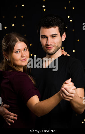 Jeune couple, homme et femme, sur fond noir, la danse Banque D'Images