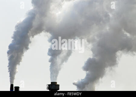Les cheminées d'une usine crachant des gaz à effet de serre et de la pollution dans l'air Banque D'Images