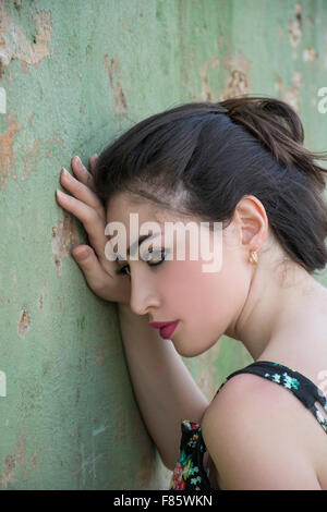 Triste jeune femme appuyée contre le mur Banque D'Images