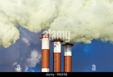 Cheminées industrielles avec plus de fumée ciel bleu Banque D'Images