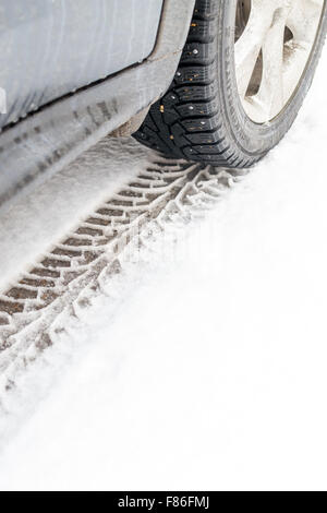 Voiture en stationnement crée pneu neige imprime dans le froid hivernal de la première tempête de neige pour frapper les utilisateurs de véhicules dans les mois d'hiver glacial Banque D'Images