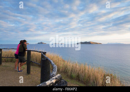 Couple looking at Bay Islands, Fidji, au lever du soleil Banque D'Images