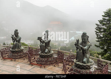 Trois statues bouddhiques en faisant des offrandes à l'Tian Tan Buddha (ou Big Buddha) à Ngong Ping, Lantau Island, Hong Kong, Chine. Banque D'Images