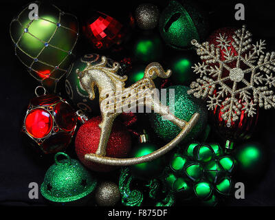 Une collection de décorations de Noël avec une boule rockinghorse dorée, des boules vertes et un flocon de neige doré. Banque D'Images
