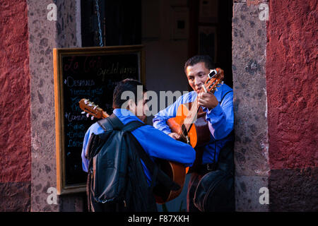 Un couple de joueurs de guitare de répéter une chanson avant d'entrer dans un restaurant à San Miguel de Allende, Mexique. Banque D'Images