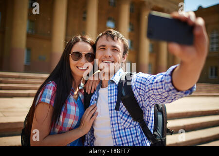 Couple de touristes faisant le beau bâtiment contre selfies Banque D'Images
