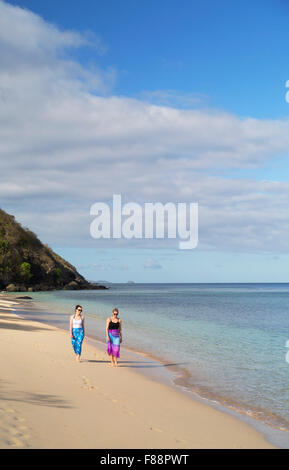 Women walking on beach Resort à Octopus, Waya Island, Yasawa Islands, Fidji (MR) Banque D'Images