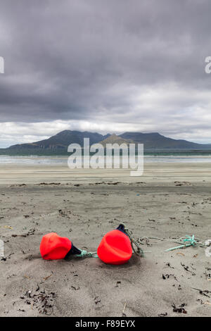 Deux bouées de pêche sur la plage de Liag Bay, à l'île de Eigg, petites îles, Hébrides intérieures, l'Écosse, l'île de Rum en arrière-plan Banque D'Images