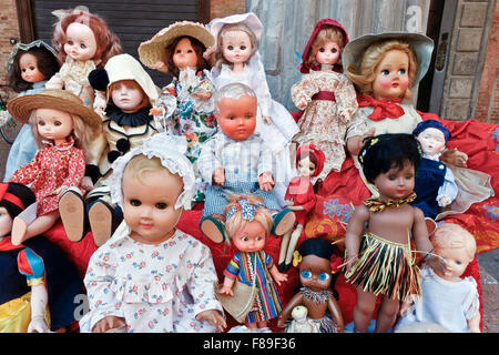 Un ensemble de poupées anciennes et anciennes en vente au marché aux puces, piazza Santo Stefano, Bologne, Emilia Romagna, Italie, UE. Jouets d'occasion, objets. Banque D'Images