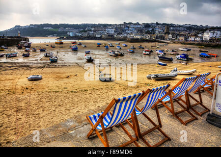 La plage de la baie de St Ives Cornwall UK Angleterre transats à la recherche d'HARBOUR HARBOUR côte littoral bateaux de pêche en attente de sable marée Banque D'Images