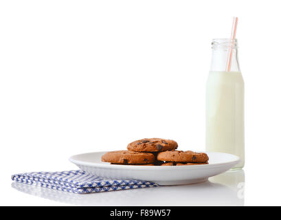 Pile de cookies aux pépites de chocolat fait maison sur une plaque en céramique blanc sur bleu serviette et bouteille de lait avec de la paille, isolated on white Banque D'Images