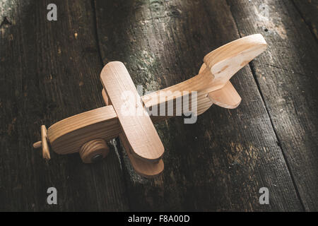 Avion en bois Vintage sur planche de bois. Soleil à travers la fenêtre Banque D'Images