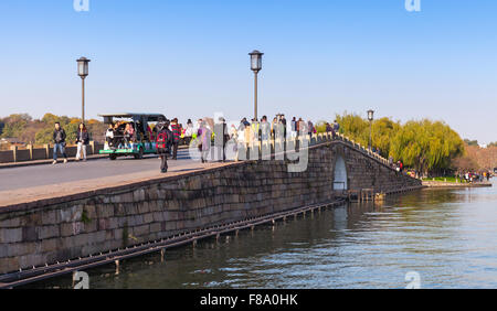 Hangzhou, Chine - décembre 5, 2014 : pont de pierre sur le lac de l'Ouest coast. Les gens ordinaires en marche célèbre parc Banque D'Images