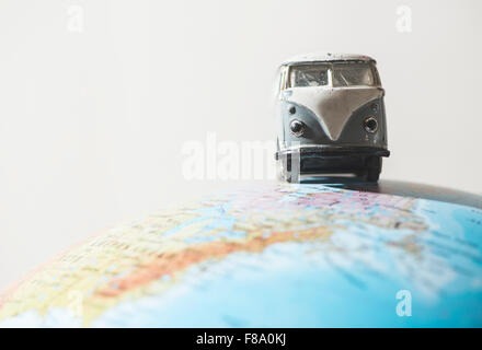 Vintage VW bus sur globe. Concept miniature Banque D'Images