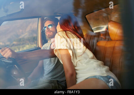 Woman kissing man driving car. Couple on road trip. Couple romantique en vacances s'amuser en voiture. Banque D'Images