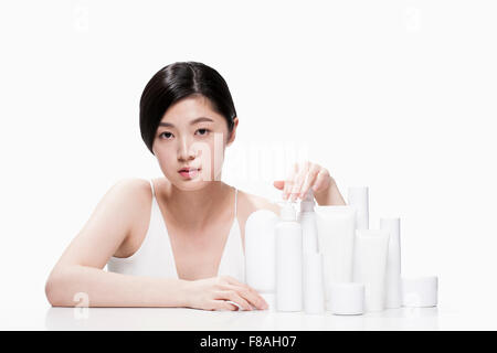 Femme assise à la table avec plaçant sa main sur divers produits sur la table Banque D'Images