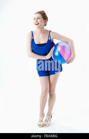 Femme avec la tenue d'un ballon de plage sous le bras Banque D'Images