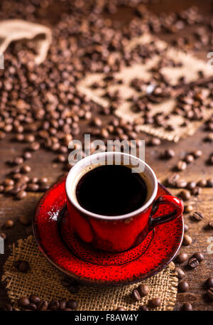 Tasse de café noir et les grains de café sur fond de bois Banque D'Images