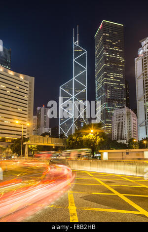 Blurred motion traffic s'engouffrent dans le quartier d'affaires central de l'île de Hong Kong at night Banque D'Images