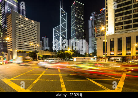 Blurred motion traffic s'engouffrent dans le quartier d'affaires central de l'île de Hong Kong at night Banque D'Images