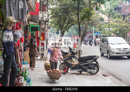 Hanoi, Vietnam - 5 novembre 2014 : une femme porte un panier de denrées alimentaires dans la façon traditionnel vietnamien à Hanoi, Vietnam capital Banque D'Images