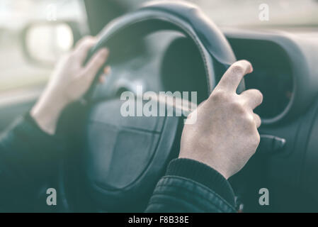 La pilote mains ronchonnant volant, femme au volant d'une voiture, avec l'image aux couleurs rétro selective focus Banque D'Images