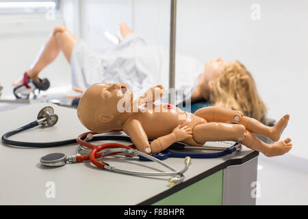 La prestation d'un étudiant sage-femme mannequin bébé à partir d'un mannequin adulte, les deux mannequins sont équipés de capteurs, de son et d'autres dispositifs conçus pour simuler un grand nombre des conditions de l'accouchement, Limoges, France. Banque D'Images